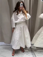 Elegante witte tweedelige set met oversized blouse en geplooide rok