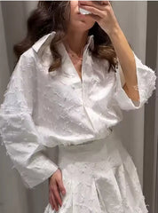 Elegante witte tweedelige set met oversized blouse en geplooide rok