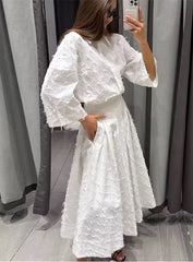 Elegante witte tweedelige set met oversized blouse en geplooide rok