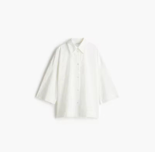 Elegante witte tweedelige set met oversized blouse en geplooide rok