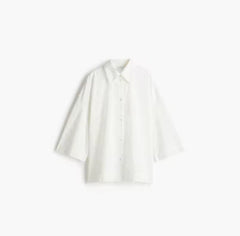 Elegante witte tweedelige set met oversized blouse en geplooide rok